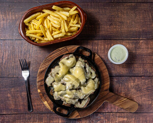 grilled meat with cheese topping and fries