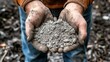 © Imron - a pile of ash for use in the vegetable garden  man holds a handful of wood ash in both hands
