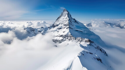 Sticker - Majestic mountain peak rising above clouds, showcasing stunning snow covered slopes and clear blue skies. breathtaking view of natures beauty and grandeur