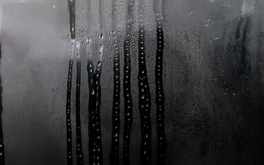 Poster - Water droplets condense on a glass surface creating streaks of moisture.