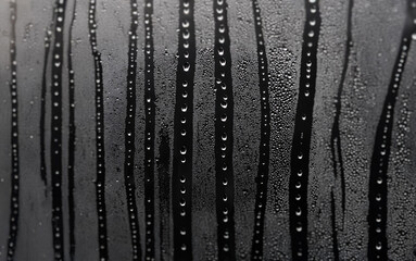 Poster - A close-up of raindrops cascading down a windowpane.