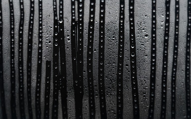 Poster - Close-up of a glass surface with vertical lines and water droplets.