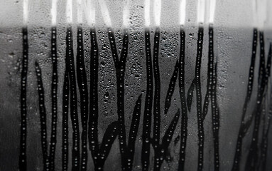 Aufkleber - A blurry image of a window with raindrops clinging to the glass, creating an abstract pattern of lines and shapes.