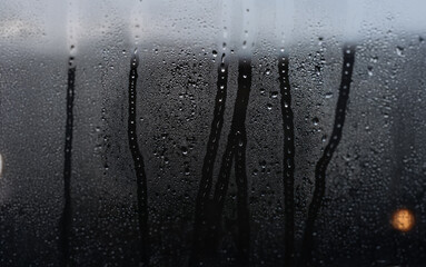 Aufkleber - Condensation and raindrops on a glass window pane, creating a blurry view of the outside.