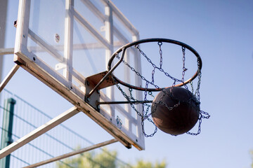 a sports ground basketball field shot from below basketball hoop with chains hitting the target bask