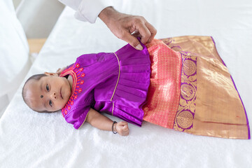 Wall Mural - An Indian family wearing traditional and casual costumes spends time with their baby, girl and grandparents in a high-rise apartment building in Kuala Lumpur, Malaysia. June 2024