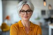 © Kishan - Portrait of a mature businesswoman holding a mobile phone in a creative office, Generative AI