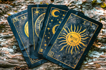 Sun tarot cards depicting celestial bodies lying on wood