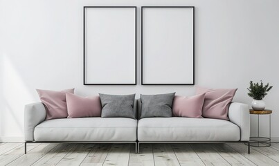 A white sofa with pink and grey pillows sits in front of a white wall with two blank picture frames A small table with a potted plant is on the right The floor is made of light wood