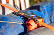 © Vera Aksionava - This is a detailed closeup shot of a ratchet strap connected to a blue tarp