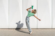 © VISTA by Westend61 - Carefree young woman shouting through megaphone in front of wall