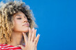 © VISTA by Westend61 - Curly haired woman with eyes closed against blue background