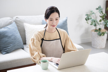 Image of a housewife who uses a computer to keep a household account, etc.