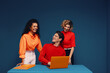 © Jacob Lund - Team of coworkers brainstorming together with laptop in bold colors