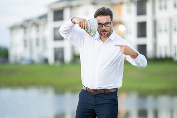 attractive man is holding cash money in one hand. joyful man with banknotes of money in his hands. b