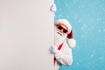 Portrait of his he nice attractive funky cheerful white-haired Santa holding copy space placard announcement promotion isolated over bright vivid shine vibrant blue color background