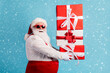 © deagreez - Profile side view portrait of his he nice attractive cheerful white-haired Santa holding in hands pile stack giftbox delivering shopping isolated bright vivid shine vibrant blue color background
