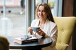 © Galka3250 - Elegant Woman Enjoying Coffee in a Cozy Cafe Setting