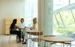 © Jacob Lund - Women engaged in an informal meeting in a modern educational setting in the city, filled with natural light and open space