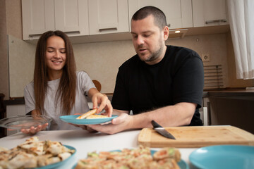 Father and daughter preparing food, indoor cooking and slicing, parent and teenage friendship