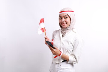 Happy smiling young Asian muslim woman holding mobile phone isolated on white background. Indonesian independence day concept