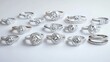 © Aziz - A collection of diamond engagement rings on a white surface.