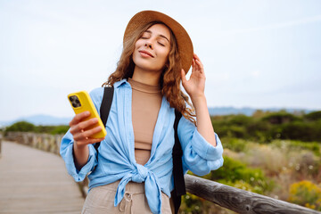 Happy woman - tourist with phone enjoying beautiful views. Europe travel. Lifestyle, vacation, nature, active life.