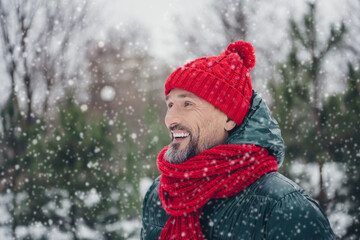 Photo of cheerful positive senior guy dressed coat choosing market x-mas fur pine outdoors urban forest park