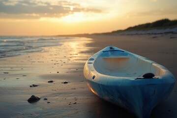 A blue kayak is sitting on the beach at sunset