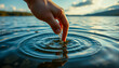 © Jacks Studio - Close-up of a hand reaching into still water with gentle ripples