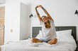 © Viktoria Kovalchuk - Enjoying a Relaxed and Easy Morning Routine While Lying in Bed with a Stretching Woman
