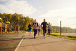 © Studio Romantic - Group of sporty smiling people in sportswear jogging together in the park. Men and women running outdoor having sport training in nature. Team of runners on workout. Sport and fitness concept.