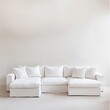 © Monty - A crisp, white sofa adorned with plush pillows stands against a stark white background, highlighting minimalist elegance and simplicity.