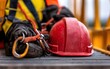 © nitnicha - A safety helmet and harness gear are placed on a metal surface, highlighting construction work and worker safety equipment.