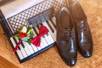 Elegant Groom's Accessories Arranged on a Vintage Piano Near a Wedding Setting.