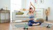 © tonefotografia - Asian woman in sportswear exercising and doing yoga in living room at home.