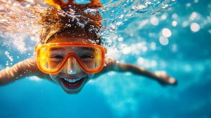 A joyful caucasian boy dives underwater with a big smile, wearing a diving mask, symbolizing summer fun, adventure, exploration, childhood joy, and water sports.