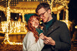 © Zamrznuti tonovi - A festive young couple is celebrating christmas eve on a street.
