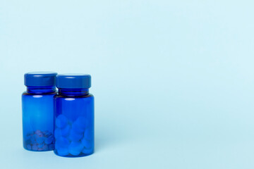 Sticker - Bottles with pills and green leaves on color background