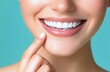 © ArtCookStudio - Smiling woman pointing at her perfect smile against a turquoise background in a bright setting