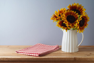 Canvas Print - Empty wooden table with red checked tablecloth and sunflowers. Thanksgiving background mock up for design and product display