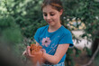 © Scopio - Child holding flowers in a garden