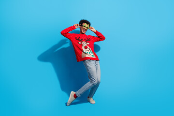 Full body photo of attractive young man disco have fun dressed red christmas sweater theme party on blue color background