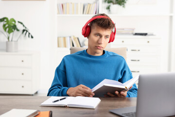 Wall Mural - Student in headphones studying at table indoors