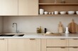 © Agus - A minimalistic kitchen with smooth light wood cabinetry, white porcelain countertops, and a simple porcelain backsplash