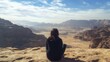 © Eleanor Richards - Woman Sitting on Cliff Overlooking Scenic Desert Landscape