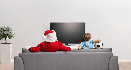 Poster - Santa claus and a boy watching tv at home