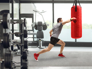 Fit man punching a boxing bag