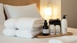 © fotofabrika - Cozy hotel room setup with soft towels and premium toiletries on a wooden tray near neatly arranged bed linens