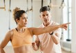 © Rizka - Female athlete listening to her trainer in the gym